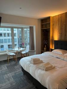 una camera con letto, tavolo e sedie di Prachtige kamer in centrum Brugge met badkamer ! a Bruges