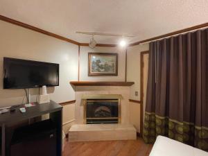 a living room with a fireplace with a flat screen tv at Super 8 by Wyndham Gananoque - Country Squire Resort in Gananoque