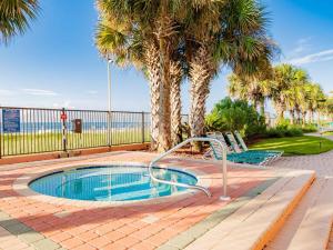 einen Pool mit Palmen und 2 Stühlen in der Unterkunft Seachase 701c in Orange Beach