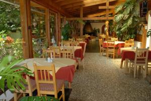 un comedor con mesas y sillas en un restaurante en Ferienwohnungen Forellenhof Waldner, en Gundersheim