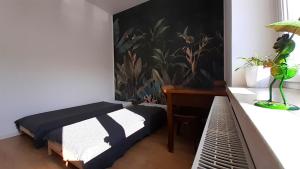 a bedroom with a bed and a desk with a plant on the wall at Urocze przestronne,w idealnej lokalizacji in Bielsko-Biała