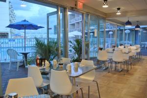 a restaurant with tables and chairs and a view of the water at The Jolly Roger Motel in Wildwood Crest