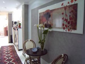 a room with a table and chairs and a vase with flowers at Hotel Scilla in Scilla