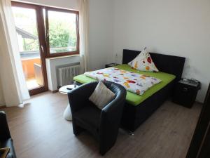 ein kleines Zimmer mit einem Bett und einem Stuhl in der Unterkunft Gästehaus Müller in Bad Schonborn