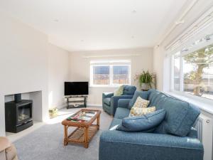 a living room with two blue couches and a fireplace at Sunnyside in Wells next the Sea