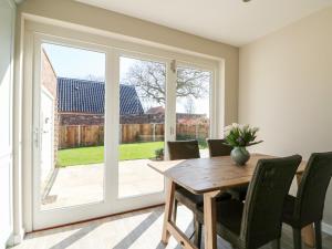 a dining room with a table and a sliding glass door at Sunnyside in Wells next the Sea