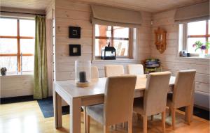 a dining room with a wooden table and chairs at Nice Home In Norheimsund With Sauna, 5 Bedrooms And Wifi in Norheimsund