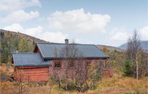 a small red cabin in the middle of a field at Nice Home In Norheimsund With Sauna, 5 Bedrooms And Wifi in Norheimsund