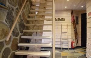 scala in legno in una camera con parete in pietra di Cozy Home In Norheimsund With Sauna a Norheimsund