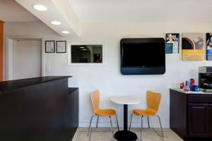 a bar with two chairs and a table and a tv on the wall at Motel 6-Rolla, MO in Rolla