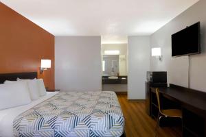 ein Hotelzimmer mit einem Bett und einem Schreibtisch mit einem Fernseher in der Unterkunft Motel 6-Rolla, MO in Rolla