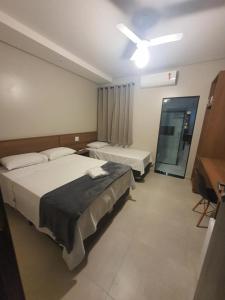 リオ・クラロにあるHotel Tertulio'sのベッドが2つと窓があるホテルの部屋