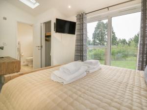 a bedroom with a large bed with towels on it at 7 Faraway Fields in Liskeard