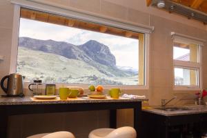 a kitchen with a view of a mountain through a window at Aguila Mora Aparts in El Chalten