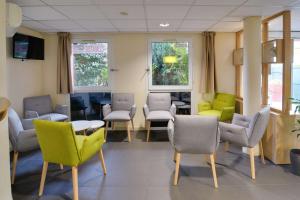 uma sala de espera com cadeiras, mesas e janelas em Sure Hotel by Best Western Nantes Saint-Herblain em Saint-Herblain