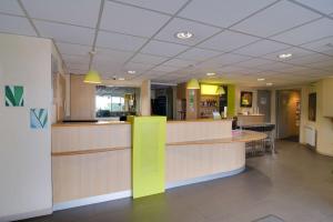 un hall de l'hôpital avec un comptoir jaune et vert dans l'établissement Sure Hotel by Best Western Nantes Saint-Herblain, à Saint-Herblain