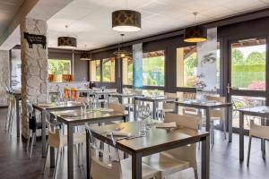 un restaurante con mesas, sillas y ventanas en Sure Hotel by Best Western Lille Tourcoing Ex Hotel Garden en Bondues