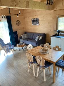 a living room with a wooden table and a couch at Domki Górskie Szlaki in Czarny Dunajec