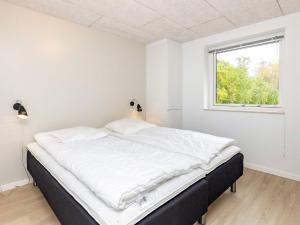 オテルプにあるHoliday Home Bjørn IIの白いベッドルーム(大型ベッド1台、窓付)