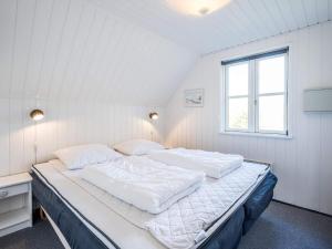 a large bed in a white room with a window at Holiday home Nørre Nebel XLIX in Nørre Nebel