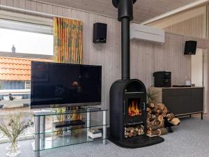 sala de estar con chimenea y TV en Three-Bedroom Holiday home in Otterup 7, en Otterup