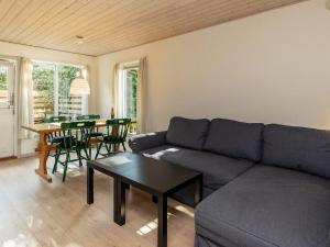 a living room with a couch and a table at Holiday Home Nordre III in Mesinge