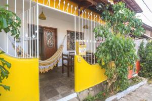 un porche delantero amarillo de una casa con una valla amarilla en Apartamentos Pipa Centro, en Pipa