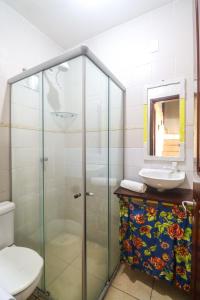 a bathroom with a glass shower and a sink at Apartamentos Pipa Centro in Pipa