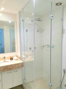 Un baño con ducha de cristal y lavabo. en APÊ DOS ANJOS - Rio de Janeiro Arraial do Cabo, en Arraial do Cabo