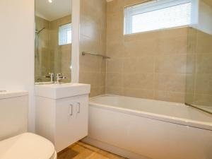 a bathroom with a tub and a toilet and a sink at 12 Horizon View in Liskeard