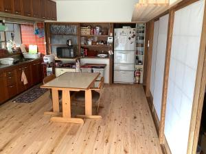 a kitchen with a table and a refrigerator at ゲストハウスやごろう in Iizuka +17 photos