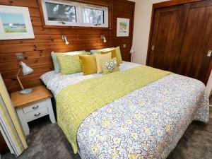 a bedroom with a bed and a wooden wall at 2 Southern Place in Liskeard