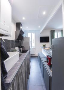 - une cuisine avec des comptoirs blancs et un réfrigérateur dans l'établissement Appartement T2 au calme Cosy - Quartier Prébendes, à Tours