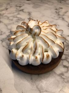 a cake with white frosting on a table at Reginaldo's home Bed&Breakfast in Nesso