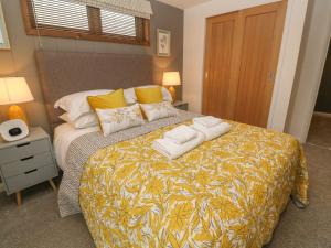 a bedroom with a bed with towels on it at 12 Meadow Retreat in Liskeard