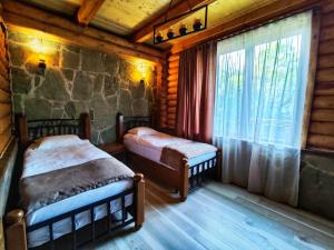 a bedroom with two beds in a log cabin at Getahovit Resort in Ijevan