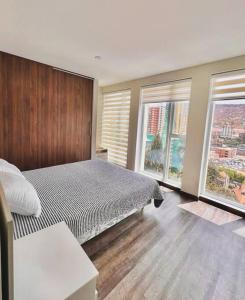 a bedroom with a large bed and two windows at Apartamento Nuevo con Hermosa Vista, Ubicación Perfecta in La Paz
