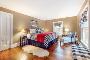 een slaapkamer met een bed en een stoel bij Pied-A-Terre in Kennebunkport