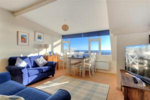 a living room with a blue couch and a table at Halyards, La Casa in Lyme Regis