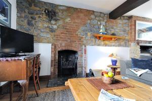 a living room with a stone wall with a fireplace at Bedrock in Lyme Regis