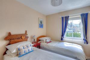 a bedroom with two beds and a window at Bedrock in Lyme Regis