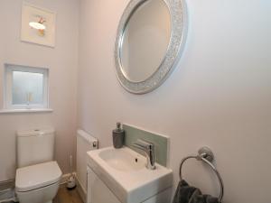 une salle de bain avec un lavabo et un miroir au mur dans l'établissement Fisherman's Rest, à Weymouth 38 autres photos