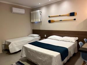 two beds in a room with baseball bats on the wall at Éolos Loft's - Cabo Frio in Cabo Frio