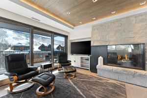 a living room with a fireplace and chairs and a tv at Altus #206 in Vail