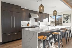 a kitchen with a large island with bar stools at Altus #206 in Vail