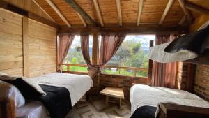 1 dormitorio con 2 camas y ventana en Chalet Amadeus Guatavita en Guatavita