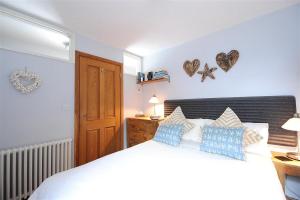 a bedroom with a large white bed with blue pillows at Seaside in Lyme Regis