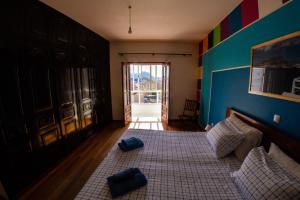 1 dormitorio con 1 cama con 2 almohadas azules en Guest House Montanha, en Mindelo