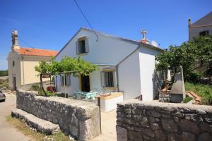 a white house with a stone wall in front of it at Holiday house with WiFi Ustrine, Cres - 8037 in Ustrine