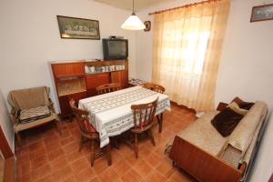 a living room with a table and a couch and a tv at Holiday house with WiFi Ustrine, Cres - 8037 in Ustrine